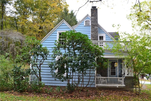 view of home's exterior with a porch and a balcony