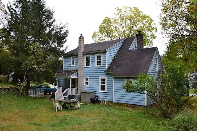 rear view of property with a lawn