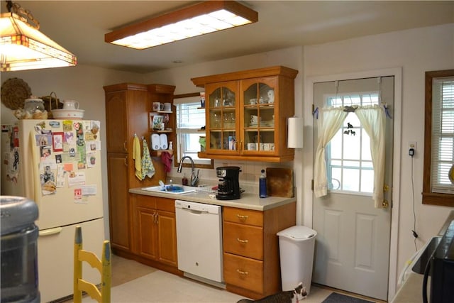 kitchen with backsplash, plenty of natural light, white appliances, and sink