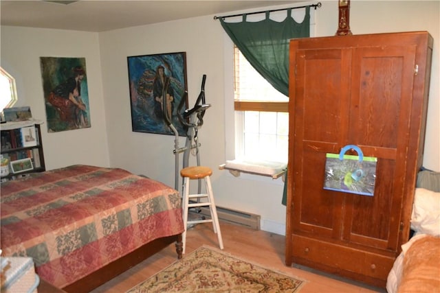 bedroom with light wood-type flooring and baseboard heating