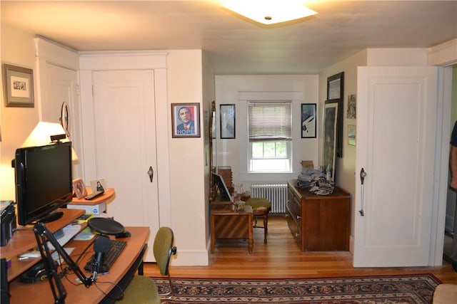 office space featuring wood-type flooring and radiator