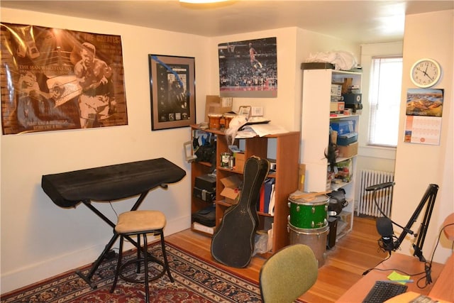 sitting room with hardwood / wood-style flooring and radiator