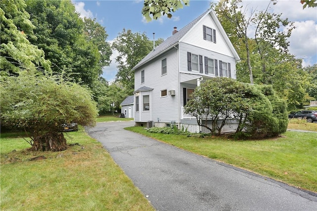 view of home's exterior featuring a lawn and covered porch