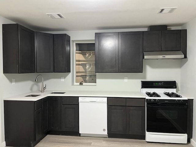 kitchen featuring light hardwood / wood-style floors, white appliances, and sink