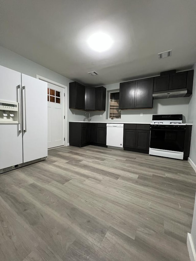 kitchen featuring light wood-type flooring and white appliances