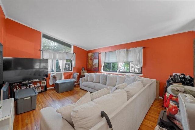 living room with lofted ceiling, light wood-type flooring, and crown molding