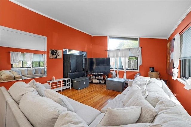 living room with ornamental molding, a healthy amount of sunlight, vaulted ceiling, and wood-type flooring