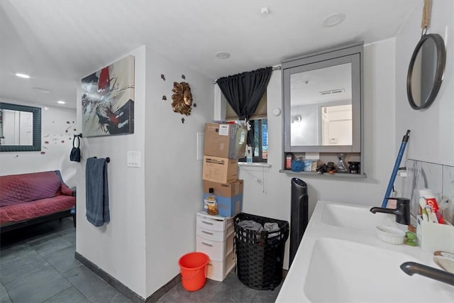 laundry room featuring sink and stacked washer and clothes dryer