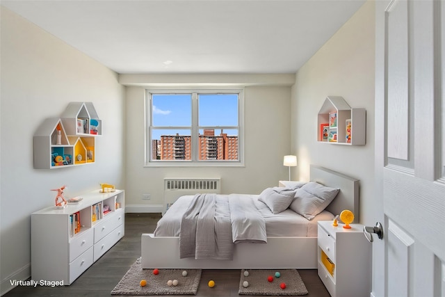 bedroom with dark hardwood / wood-style flooring and radiator