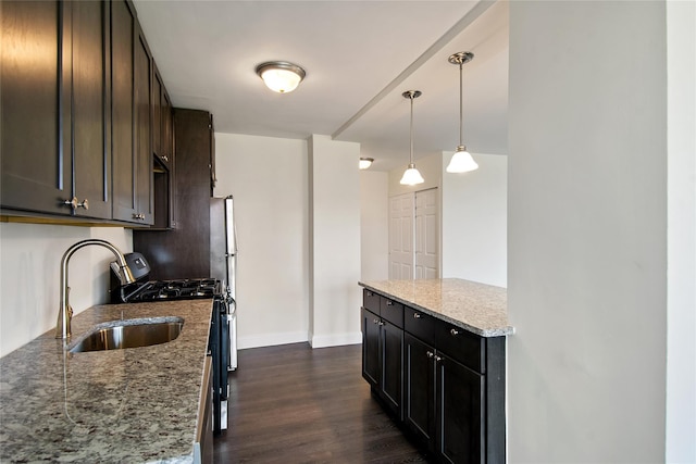 kitchen with sink, light stone counters, decorative light fixtures, dark brown cabinets, and dark hardwood / wood-style floors