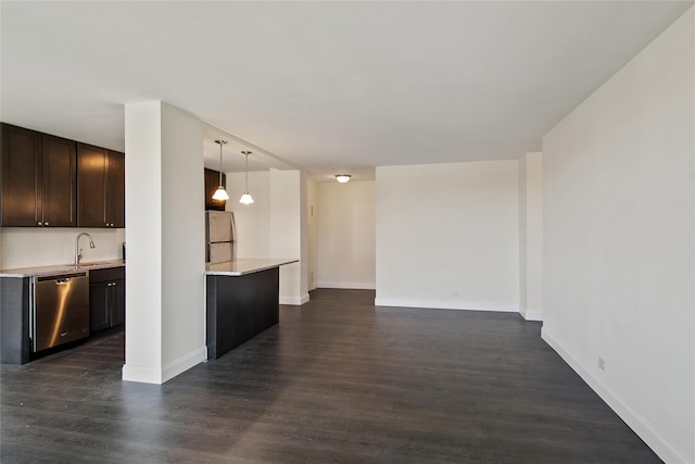 kitchen with appliances with stainless steel finishes, dark hardwood / wood-style floors, sink, hanging light fixtures, and dark brown cabinetry