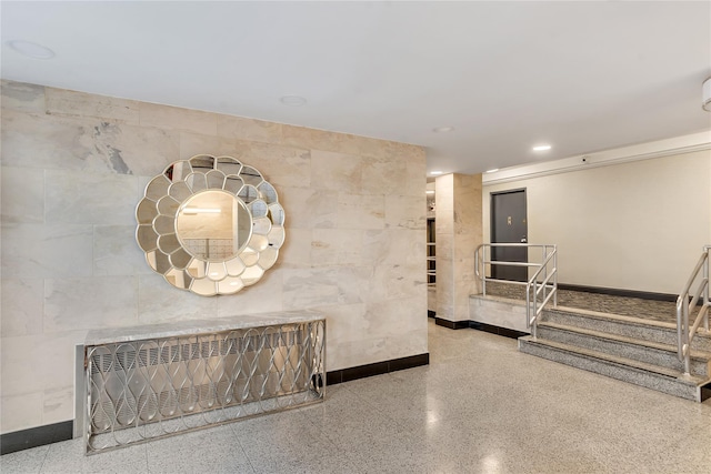 hallway featuring radiator heating unit and tile walls