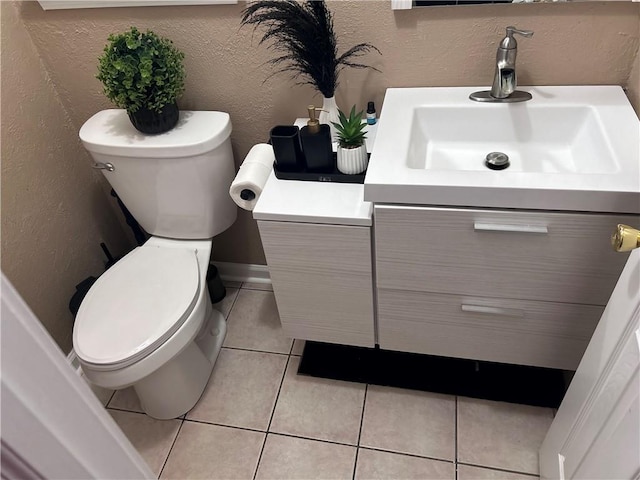 bathroom with tile patterned flooring, vanity, and toilet