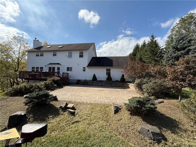 rear view of property featuring a wooden deck