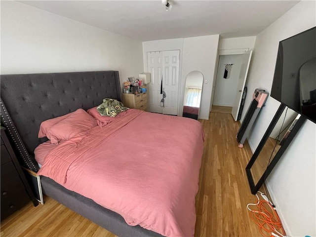 bedroom with light wood-type flooring and a closet