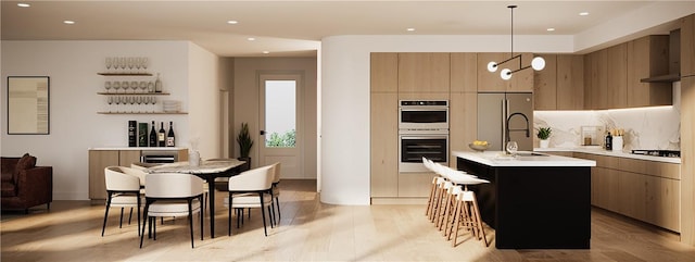 kitchen featuring a kitchen island with sink, hanging light fixtures, light hardwood / wood-style flooring, a notable chandelier, and stainless steel appliances