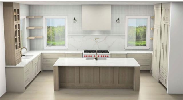 kitchen featuring a center island with sink, sink, white stove, and tasteful backsplash