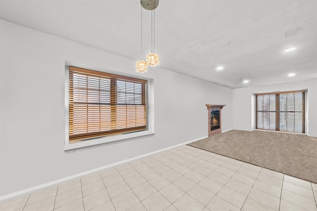 unfurnished living room featuring light colored carpet and a brick fireplace