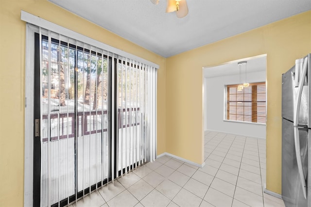 tiled spare room with ceiling fan and a textured ceiling