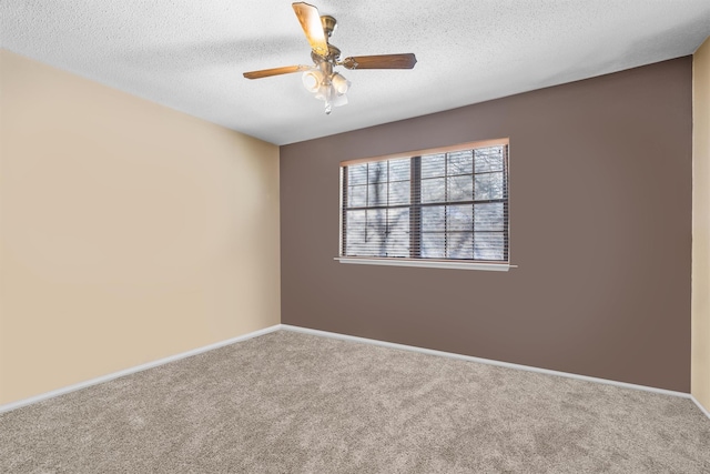 empty room featuring ceiling fan, carpet floors, and a textured ceiling