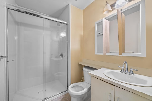 bathroom with tile patterned floors, vanity, toilet, and a shower with door