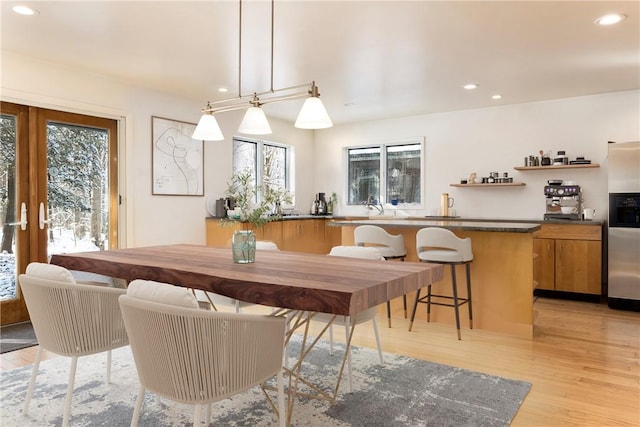 dining room featuring sink, light hardwood / wood-style floors, and french doors