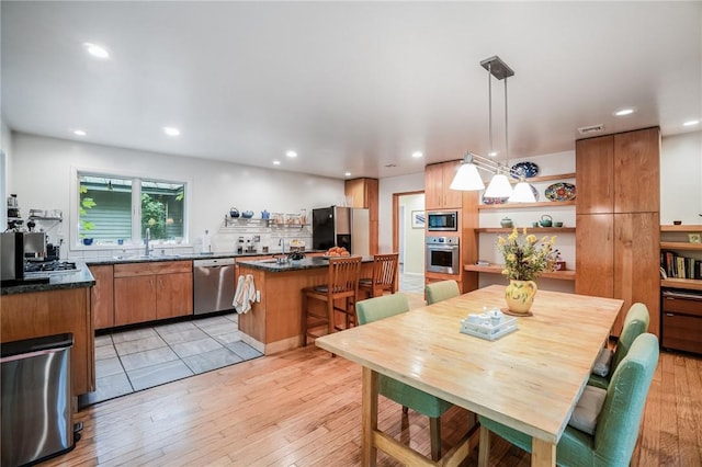 dining space with sink and light hardwood / wood-style flooring