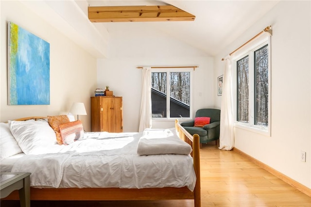 bedroom featuring vaulted ceiling with beams and light wood-type flooring