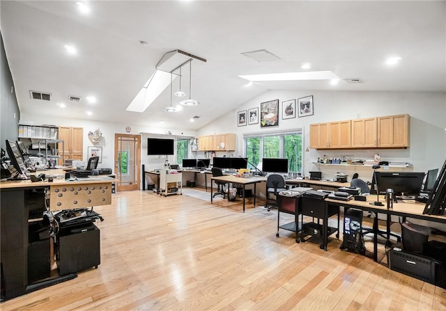 office with lofted ceiling with skylight and light hardwood / wood-style flooring