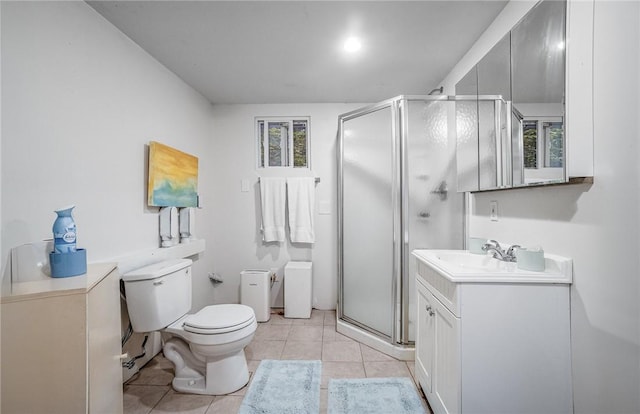 bathroom with toilet, vanity, tile patterned floors, and a shower with door