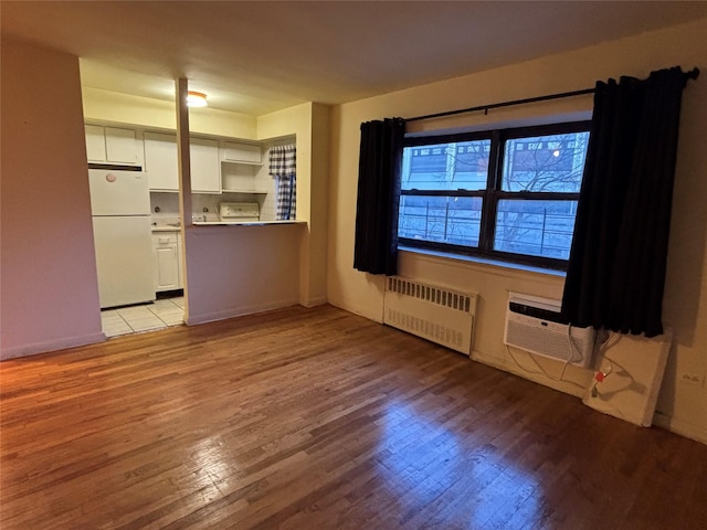 2545 Sedgwick Ave Unit 6F, Bronx, NY 10468 - unfurnished living room featuring radiator heating unit, light wood-style flooring, and an AC wall unit