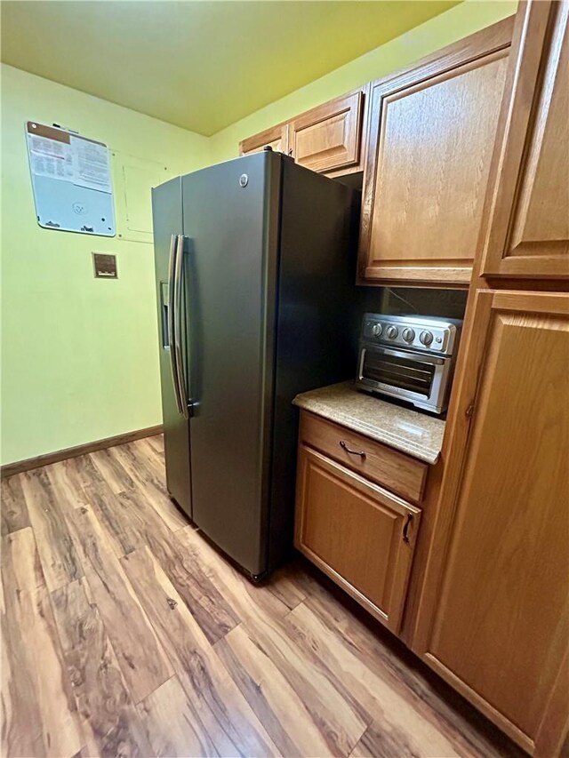 kitchen with light wood-type flooring and stainless steel refrigerator with ice dispenser