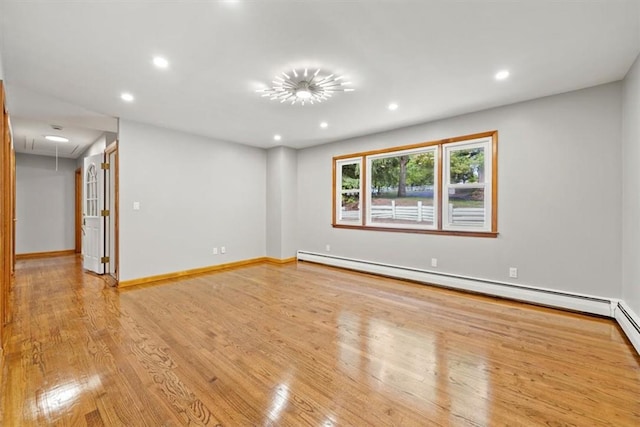 unfurnished room with light wood-type flooring and baseboard heating