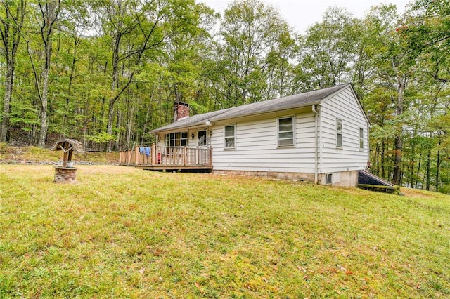 rear view of property with a deck and a lawn