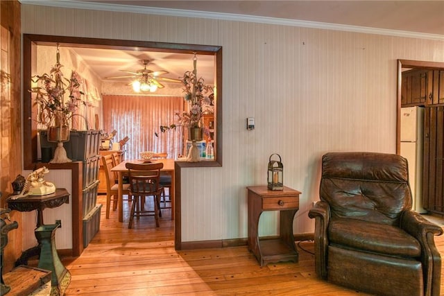 sitting room featuring ceiling fan, ornamental molding, and light hardwood / wood-style flooring