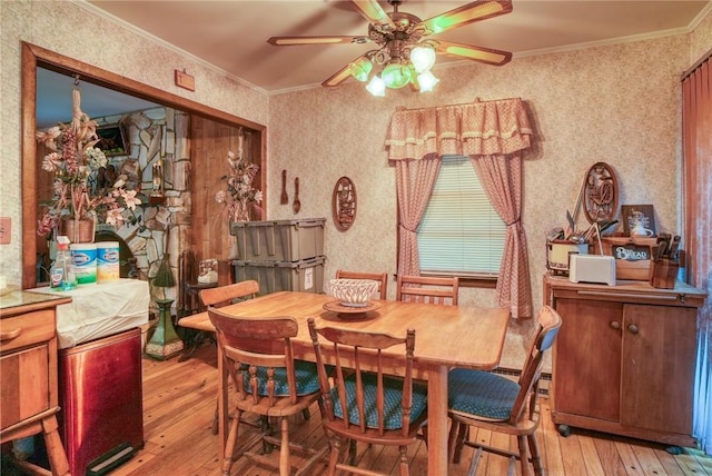 dining room featuring ceiling fan, crown molding, and light hardwood / wood-style flooring