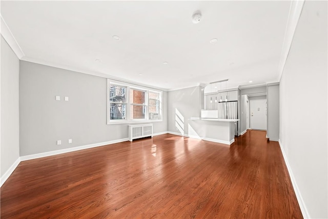 unfurnished living room featuring radiator heating unit, dark wood-type flooring, and ornamental molding