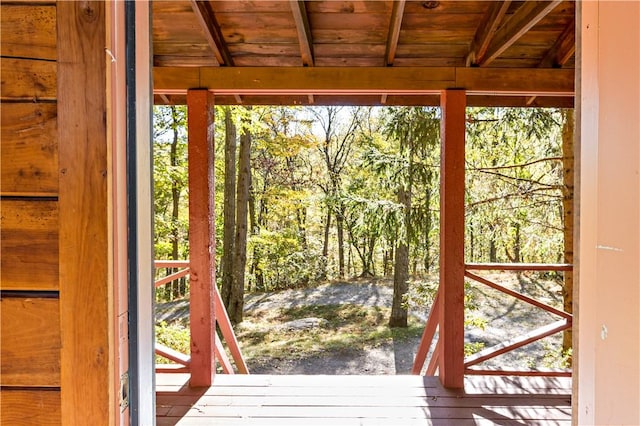 doorway to outside with a wealth of natural light, beamed ceiling, and wood ceiling