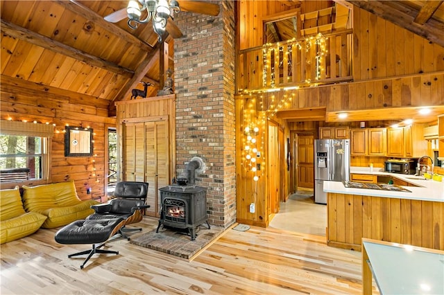 living room with wood ceiling, beam ceiling, high vaulted ceiling, light hardwood / wood-style floors, and a wood stove