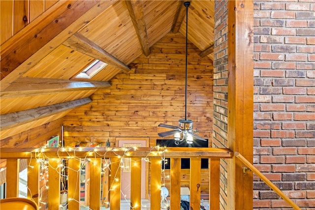 interior space featuring a skylight, wood ceiling, ceiling fan, wooden walls, and beam ceiling