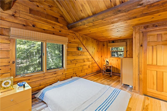 bedroom with wooden walls, light hardwood / wood-style flooring, wooden ceiling, and vaulted ceiling