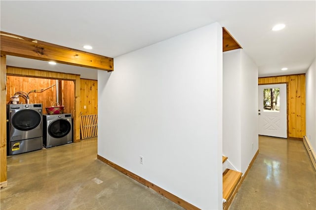 clothes washing area featuring wood walls and separate washer and dryer