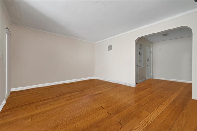 empty room with crown molding and hardwood / wood-style floors