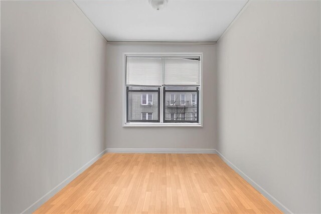 unfurnished room with crown molding and light hardwood / wood-style flooring