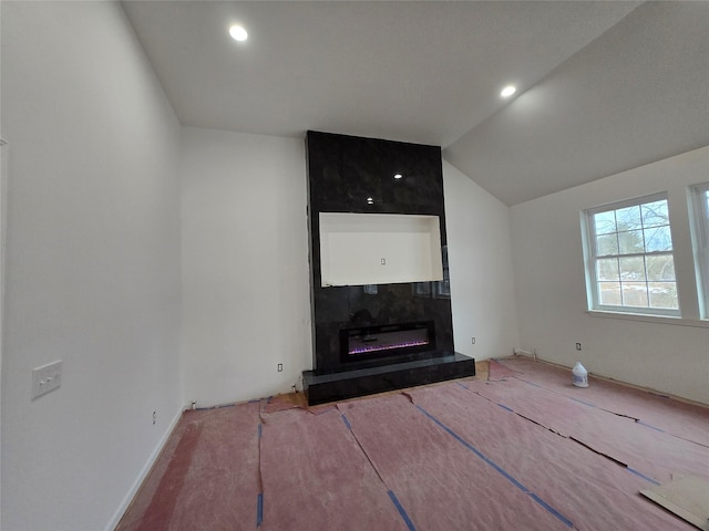 unfurnished living room featuring lofted ceiling, a fireplace, and recessed lighting