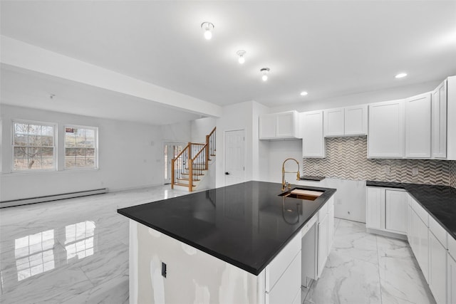 kitchen featuring marble finish floor, baseboard heating, dark countertops, and a sink