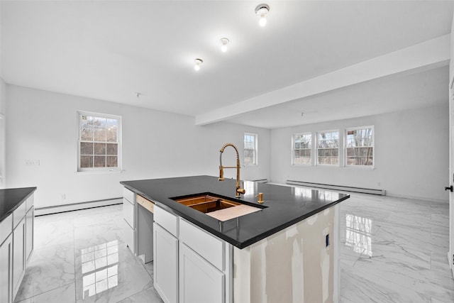 kitchen featuring marble finish floor, a sink, dark countertops, and baseboard heating