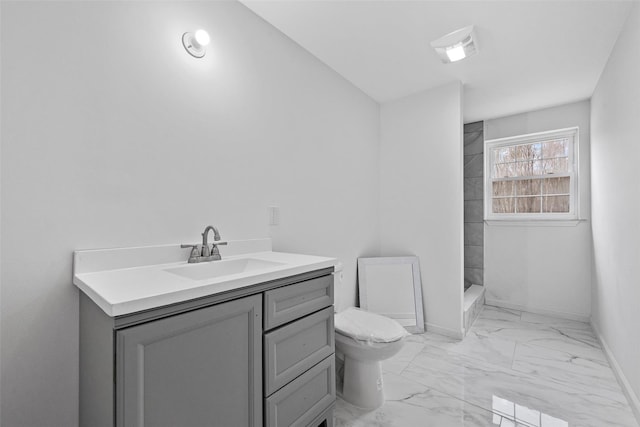 bathroom with a shower, baseboards, marble finish floor, toilet, and vanity