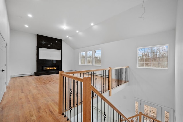 hall featuring a baseboard radiator, light wood-type flooring, recessed lighting, and a wealth of natural light
