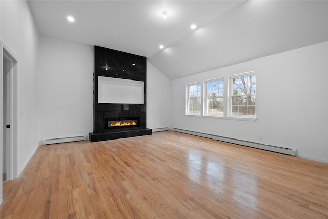 unfurnished living room featuring a large fireplace, light wood-style flooring, and a baseboard heating unit